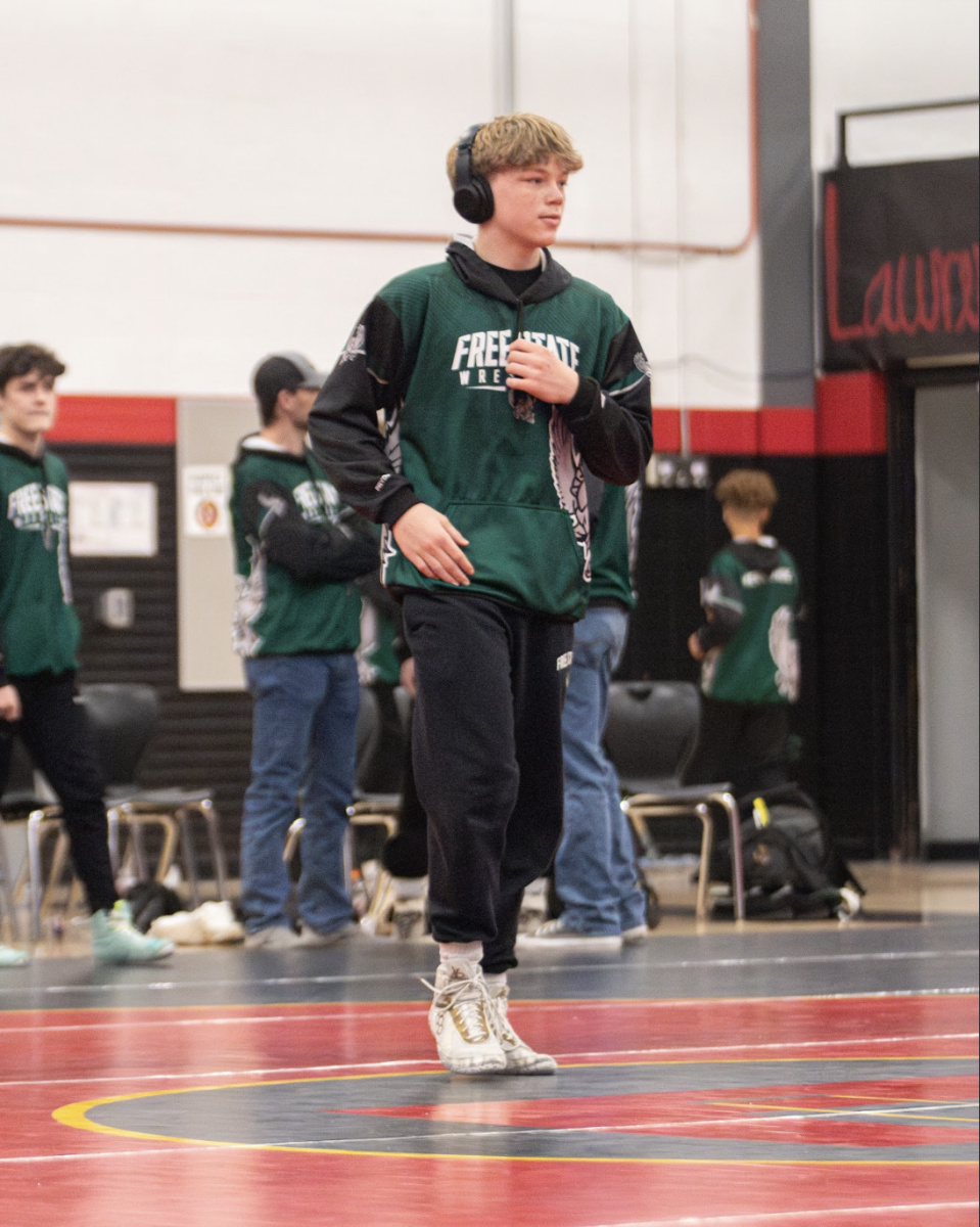 Crossing the mat, junior Grayson Hagen prepares to shake hands with his opponent from Lawrence High before his wrestling match during the City Showdown on Jan 24. 
