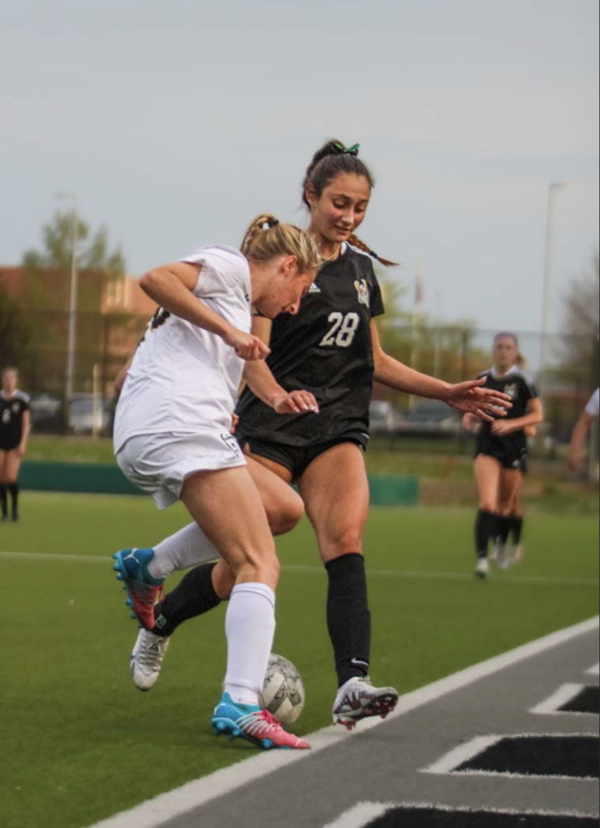 Senior Elaina Zung fights for the ball against an opposing player from Shawnee Mission West on April 14, 2023. 
