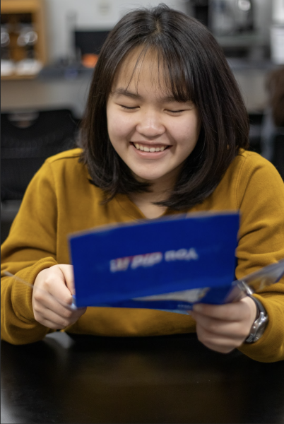 Opening an acceptance letter, senior Nina Chieu expresses interest in attending the University of Kansas. Chieu has prepared for college by taking AP classes and doing dual-enrollment through Barton Community College. “[Taking college courses while in highschool] is nice because it will lighten up my course load in college, so when I join college, I can start my major specific courses,” Chieu said. 
