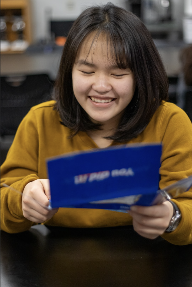 Opening an acceptance letter, senior Nina Chieu expresses interest in attending the University of Kansas. Chieu has prepared for college by taking AP classes and doing dual-enrollment through Barton Community College. “[Taking college courses while in highschool] is nice because it will lighten up my course load in college, so when I join college, I can start my major specific courses,” Chieu said. 
