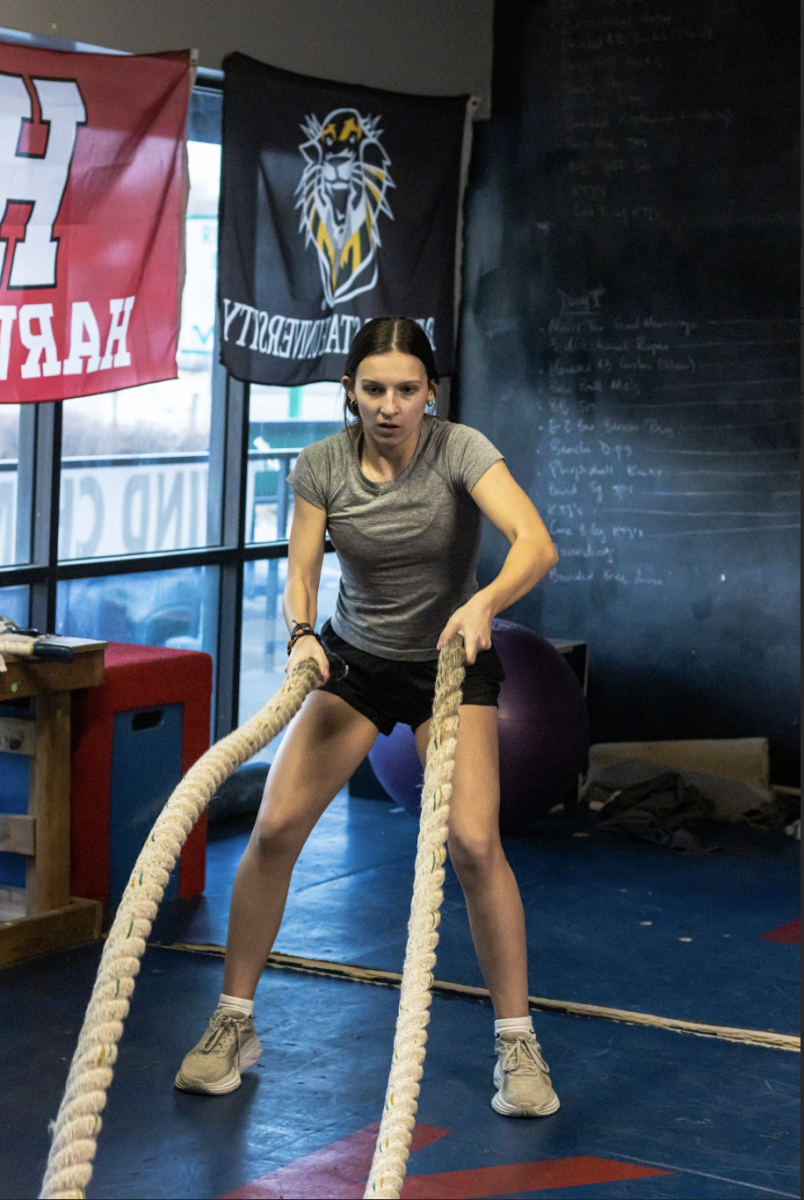 Working hard, sophomore Madeleine Landry throws the ropes during her workout. Landry has been going to Ubuntu performance for two years. “My favorite part is the environment and the people,” Landry said. 
