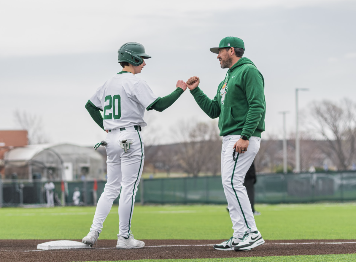 Freshman Ryker Mahnke bumps fists with the Free State assistant baseball coach during the home Varsity Baseball game vs Brandon Valley on March 23. Free State won the game 11-1. 