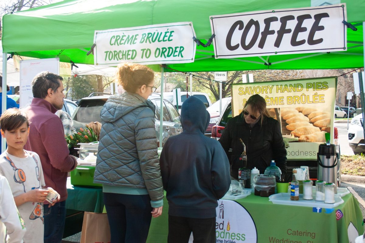 On the opening day of the farmer's market, a family waits as their crème brûlée is prepared. 