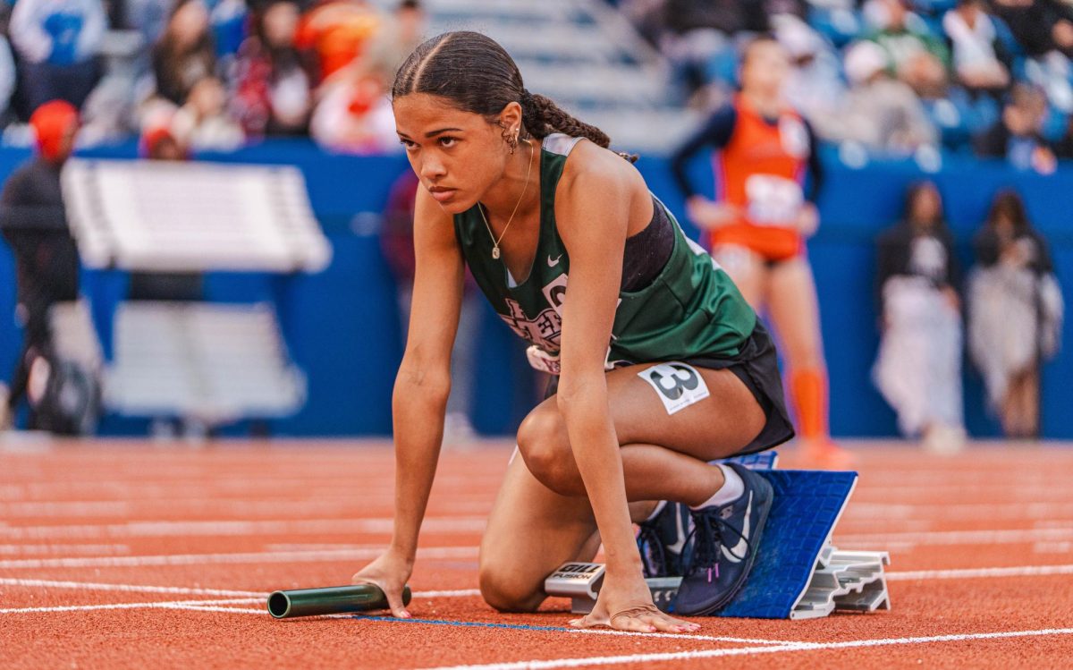 Standing in her starting blocks, sophomore Aiyanna Moss looks ahead in preparation for her relay. 