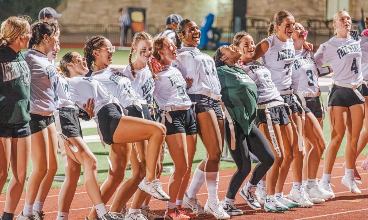 In a line, the Girls' Flag Football team celebrates together.