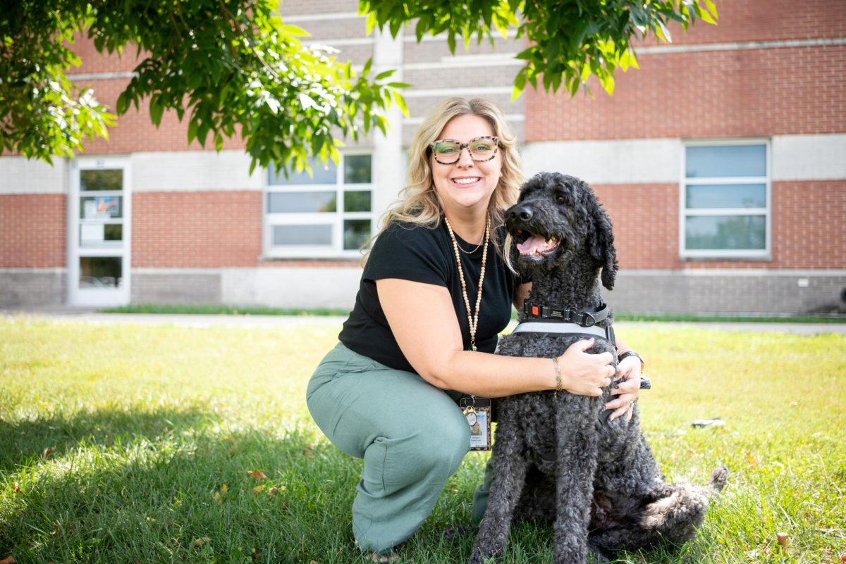 New counselor Kelsey Spencer hugs new therapy dog Apollo.