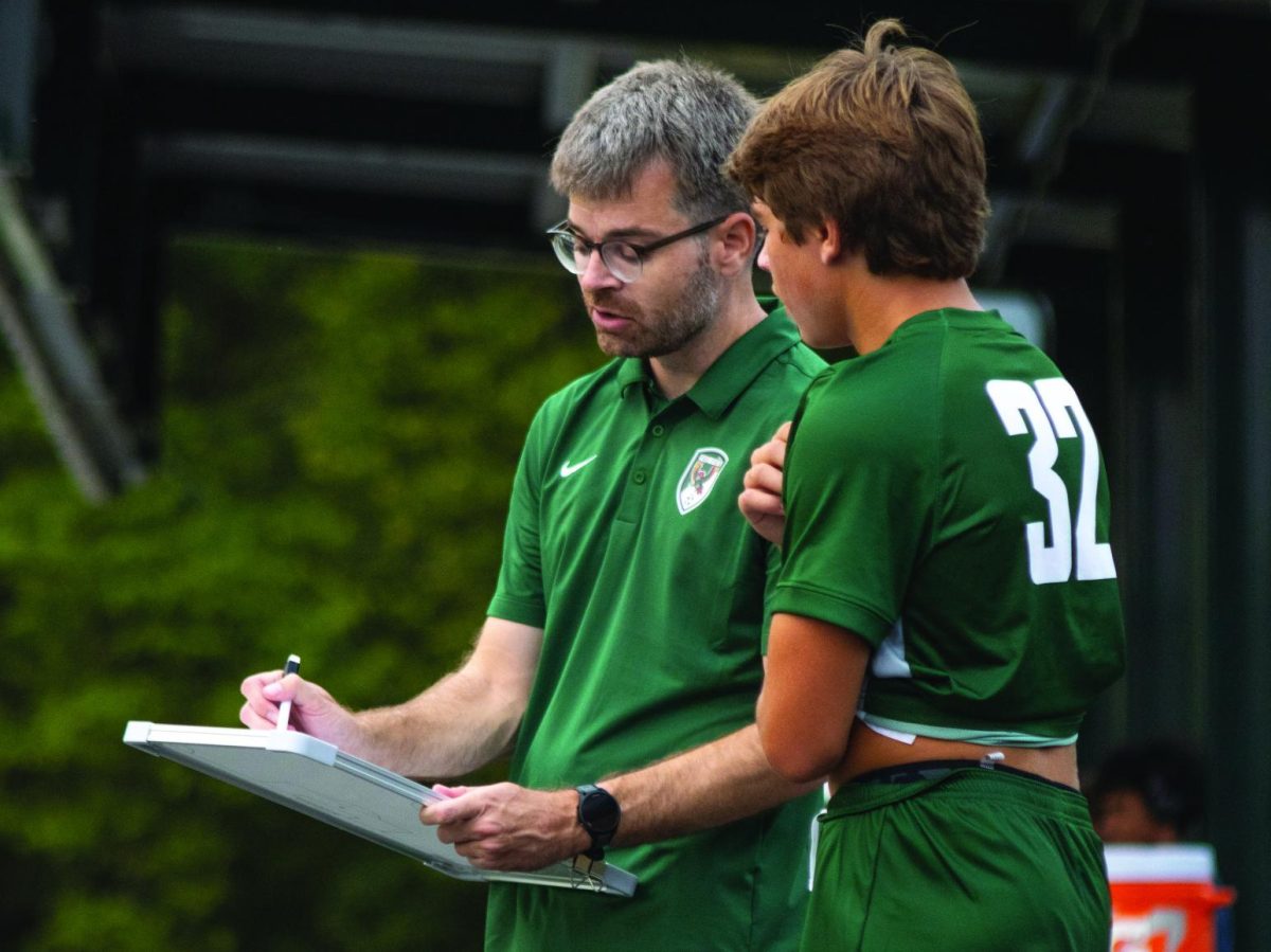 On the sidelines, coach Daniel Schoettmer discusses strategy with freshman Hoyt Jeter during the JV game against Shawnee Heights.