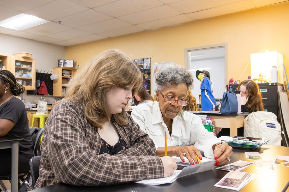 Reading the instructions, paraeducator Helen Barbee helps a student in Biology. 