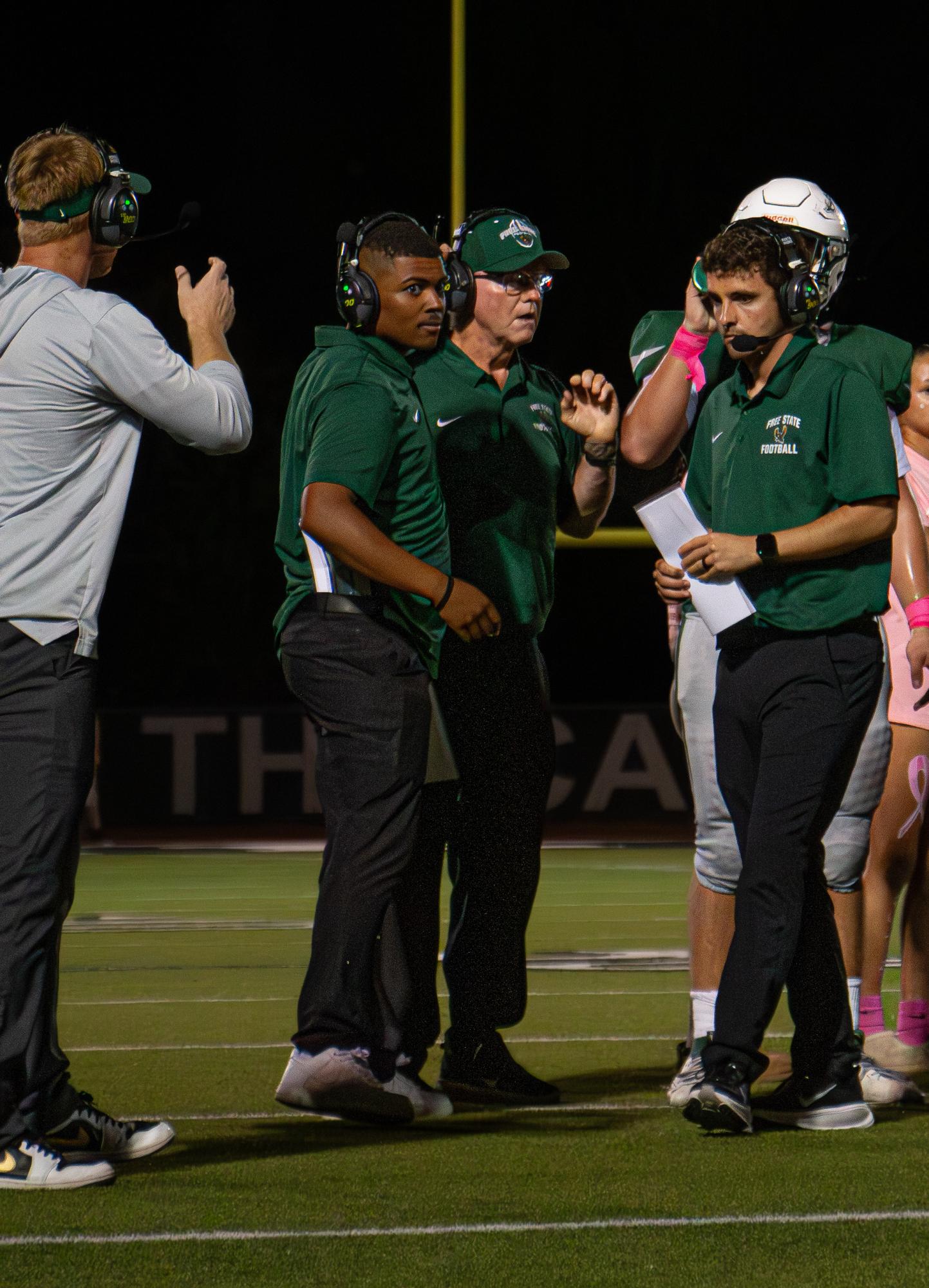 As a group, the football administrators discuss a play.