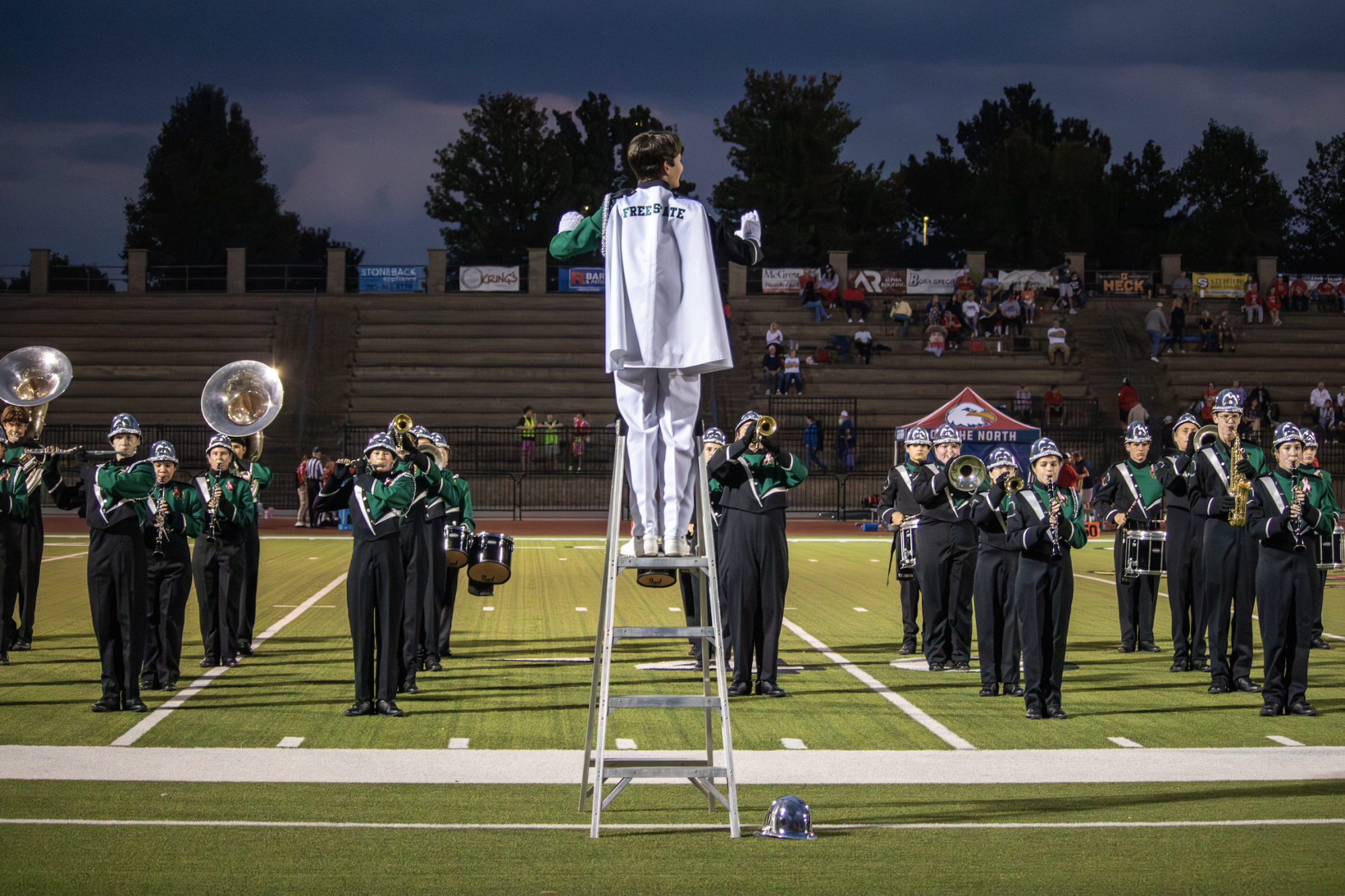 As drum major, senior Anders Benson conducts the marching band during half time.