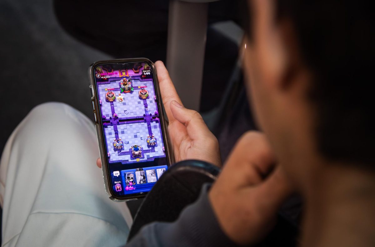 Phone in hand, sophomore Aiden Gonzalez plays a round of Clash Royale.