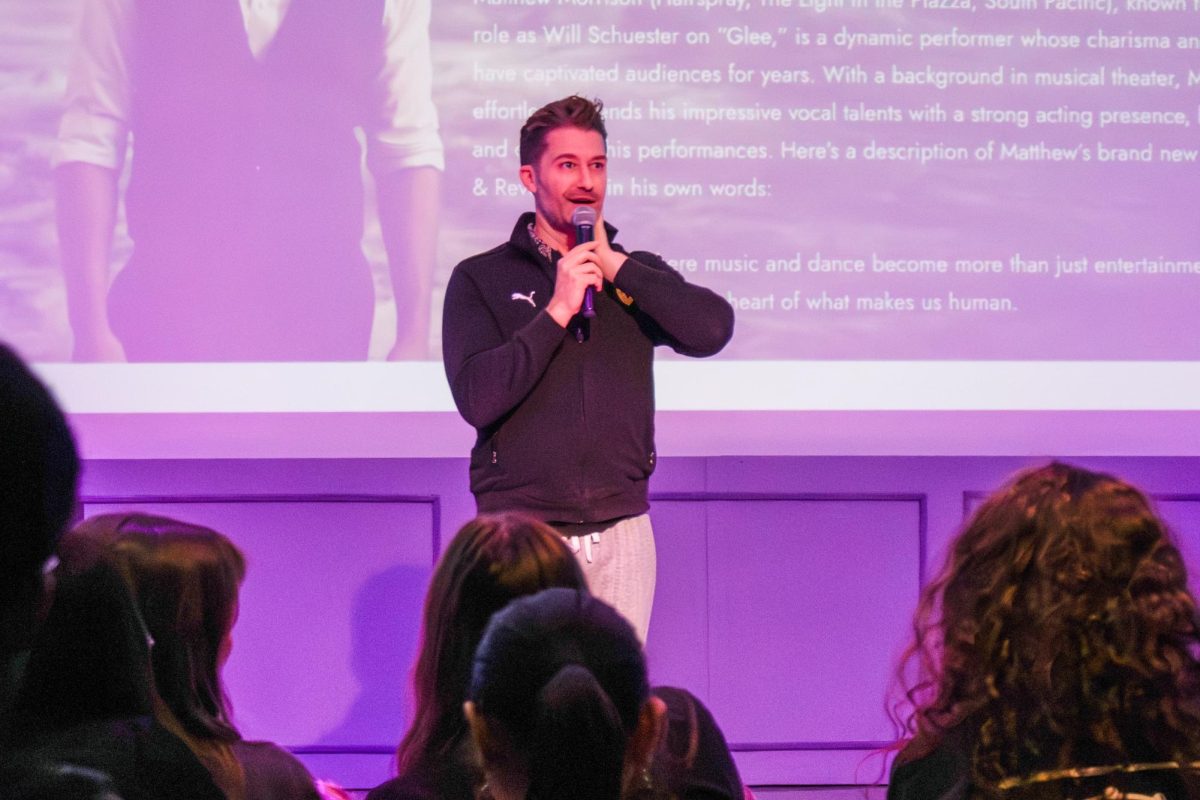 Speaking into a microphone, Matthew Morrison introduces his master class.