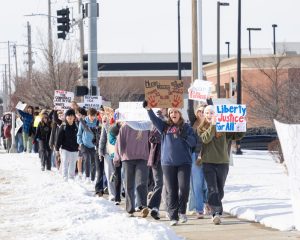 Leading the group, seniors Laura Turner and Piper Northrop protest U.S. Immigration and Customs Enforcement. Students walked 1.6 miles around the Free State block. "It's important that, even if you aren't personally being targeted, that you show support for everyone living in fear of a corrupted system right now," Turner said.
