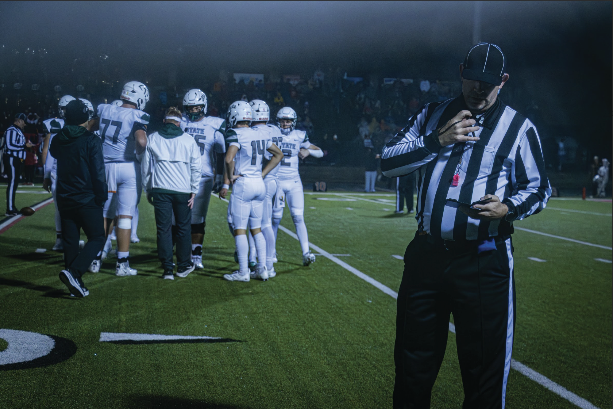 During a time out, a referee consults a playback at the Free State vs. Lawrence High rivalry game on Oct. 23, 2025.