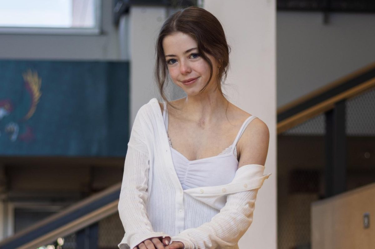 Sitting on the learning stairs, senior Maria Mosconi smiles for the camera.