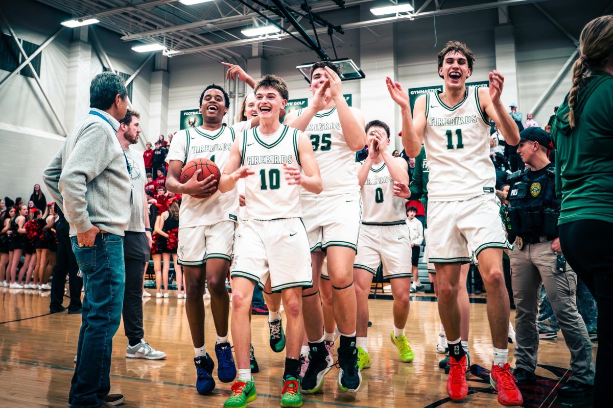The Boys Basketball team celebrates after winning the game 63-49.