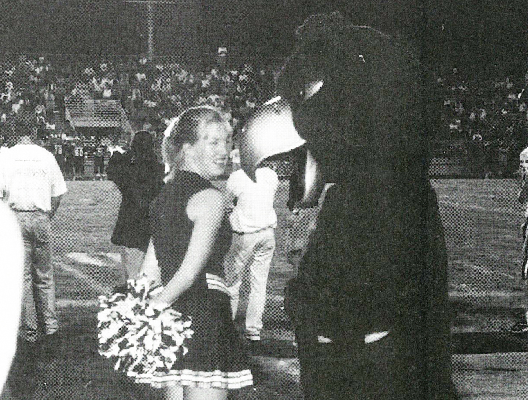 At Haskell Stadium, Kindra Bartz visits with Jodi Kesinger in 1997. Kesinger appeared at all home varsity football games. Photo by Cheryl Hawley from the Free State Journalism Archives.